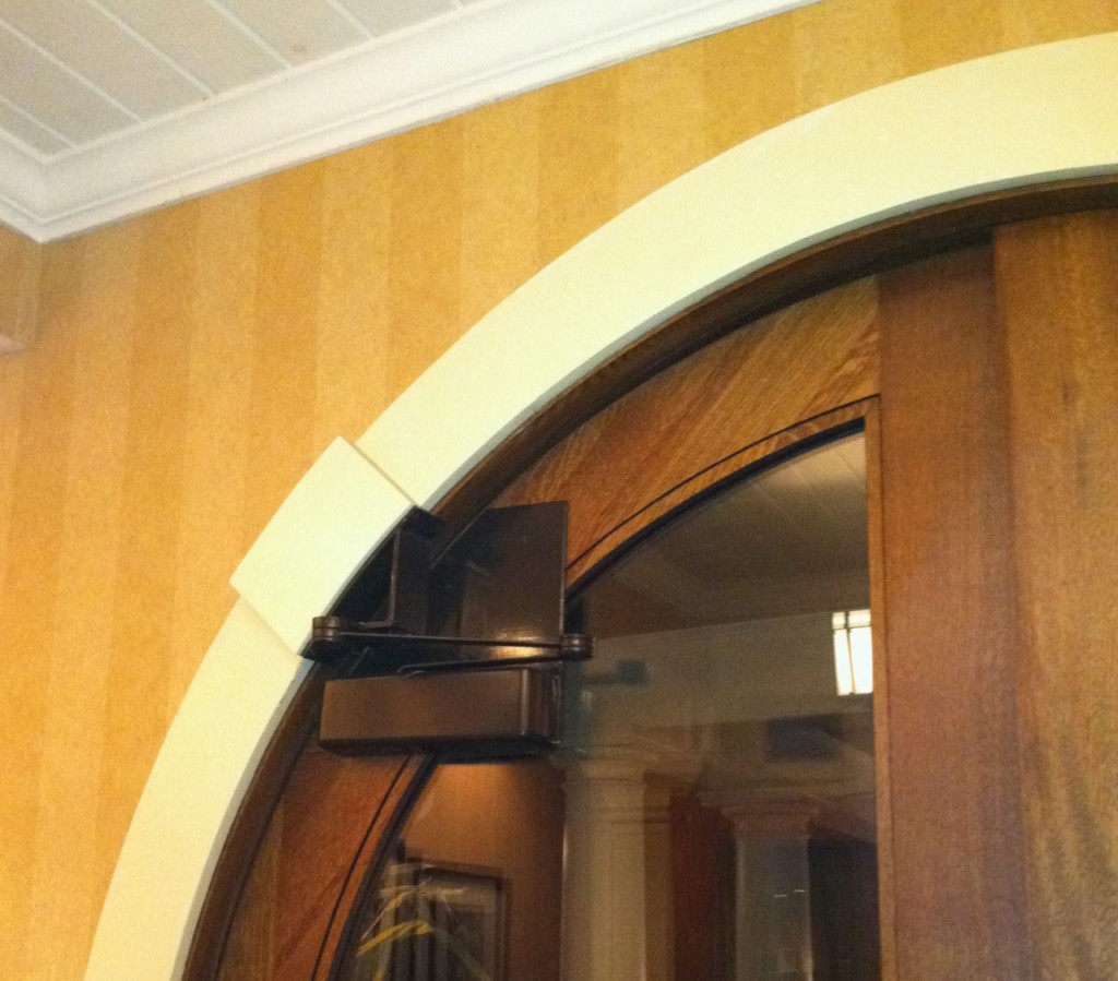Arched door with closer