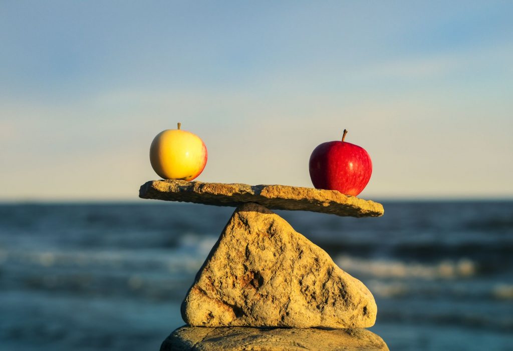 Two apples balanced on a stone like a scale