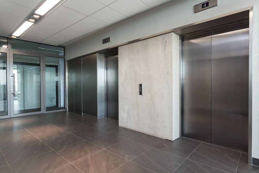 The International Building Code (IBC) and NFPA 101-Life Safety Code include different requirements for providing security and allowing egress from an elevator lobby to a tenant space.  Because the IBC doesn't currently include a section similar to NFPA 101 regarding elevator lobby egress, some states and local jurisdictions have modified the model codes in order to allow elevator lobby doors to be locked.  It's very important to know which code is being enforced and what requirements apply to the elevator lobby doors in a project's jurisdiction.