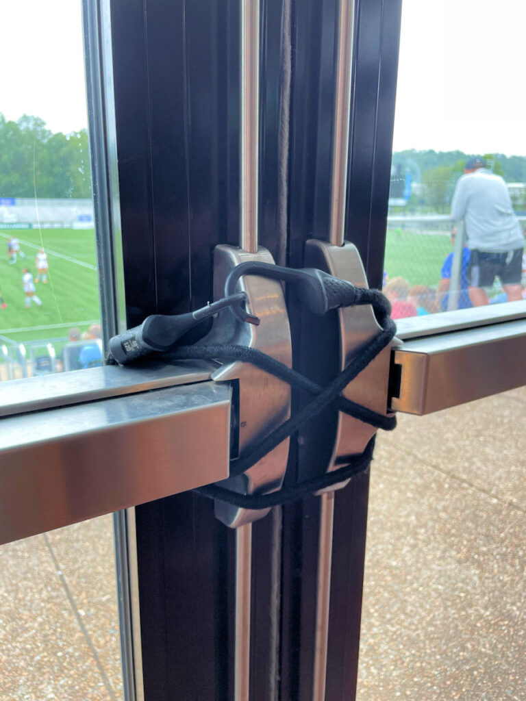 I'm wondering why these doors swing toward the soccer field, but it's hard to know the egress route without a floor plan.  Regardless, someone has solved the problem of unauthorized access to the stands with today's non-code-compliant Fixed-it Friday modification.