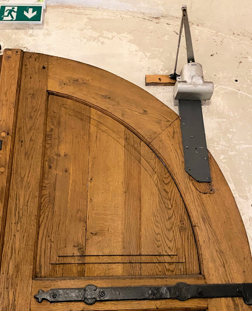 Arched door with closer